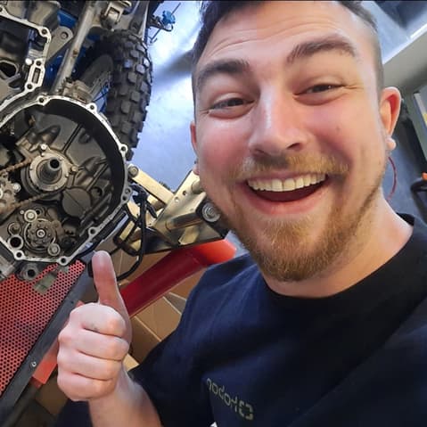 Technicus Wout poseert met een motorblok